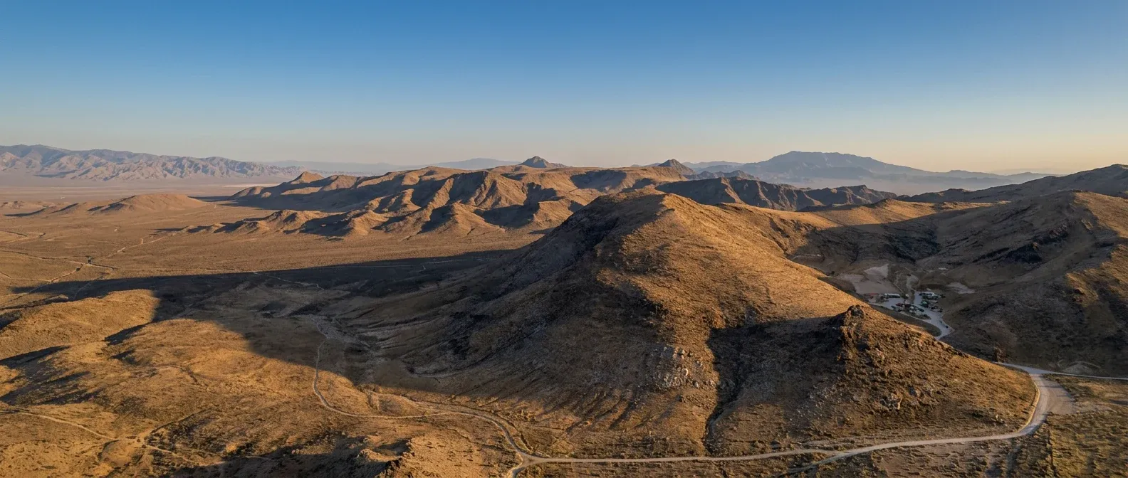 Aerial view of Adrenaline Mountain's Mojave Desert trails and sunlit mountain ridges
